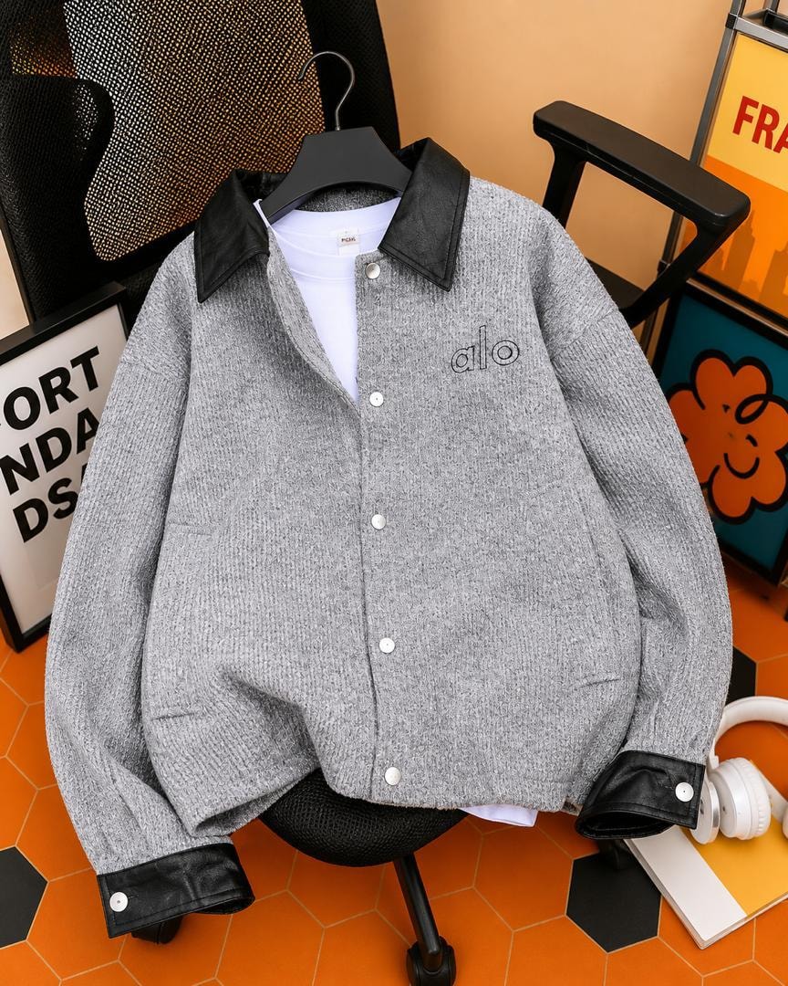 Gray bouclé jacket with black leather collar and cuffs shown on hanger over white tee.
