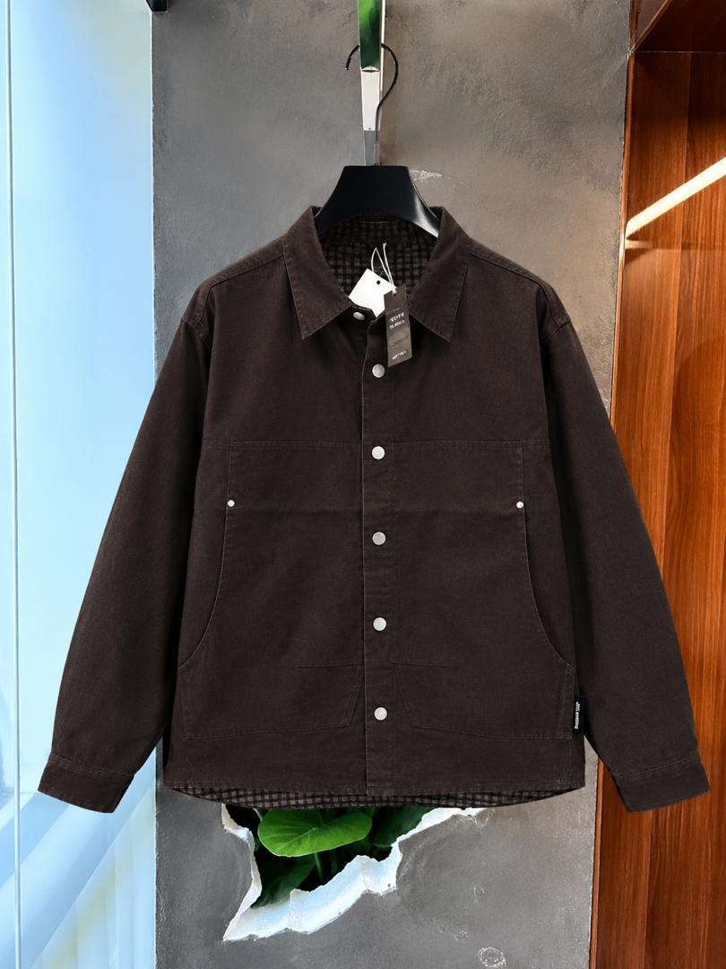 Brown twill overshirt jacket hanging with visible tags and checkered lining.